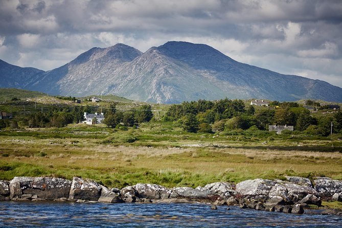 Rocky lake shore and moorland in front of a range of bare mountains